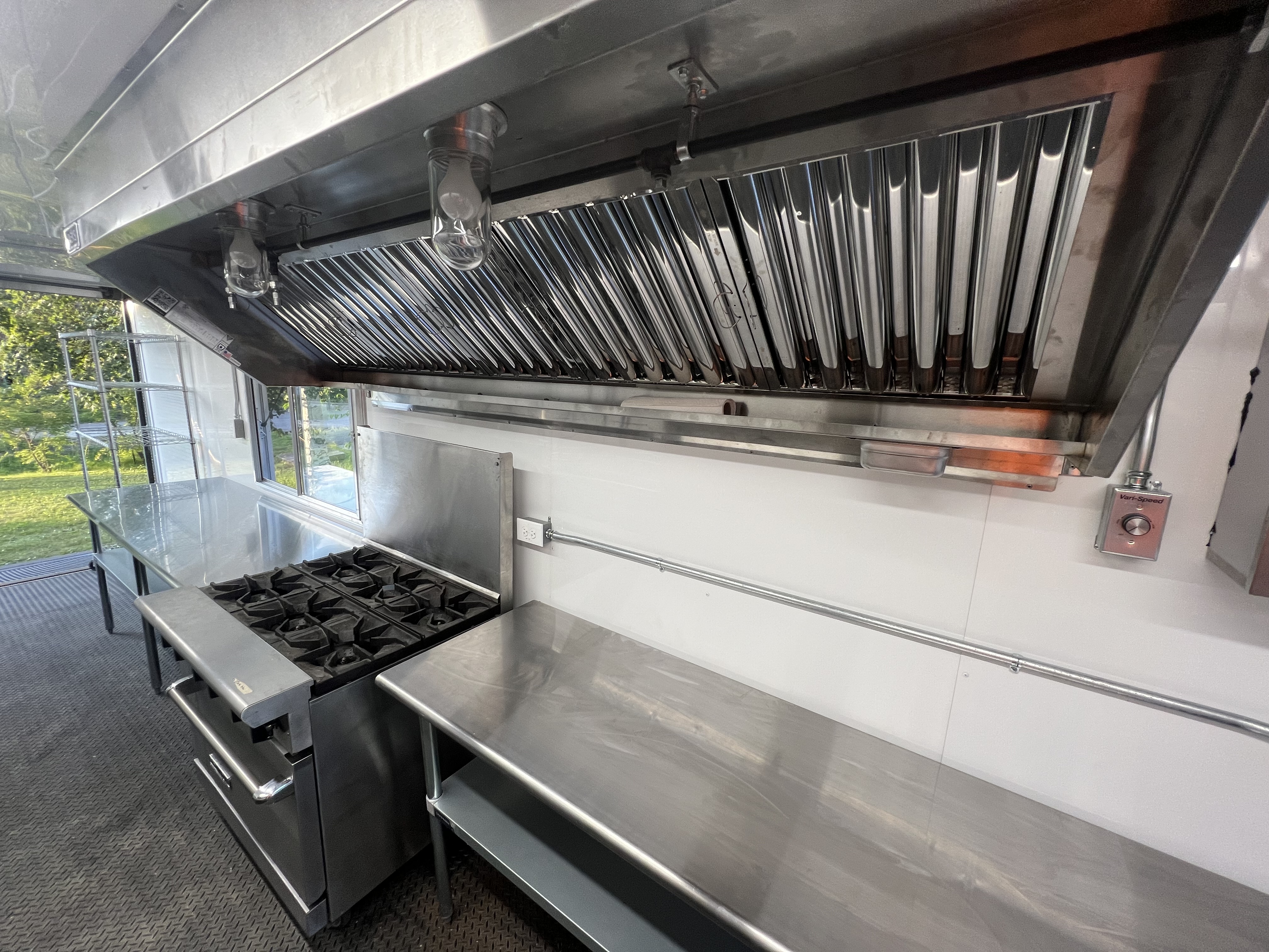 Interior view of the kitchen showing the commercial grade stove and exhaust hood